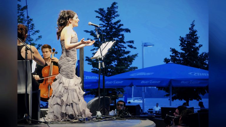 Darya Dadvar singing with a cellist on an outdoor stage by the lake, Tirgan 2011