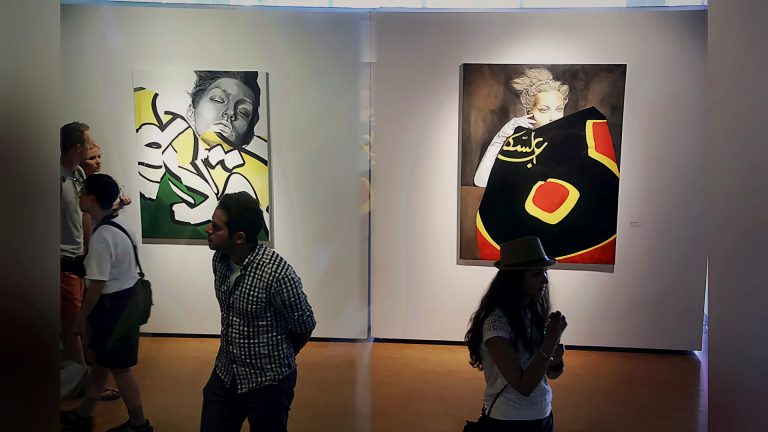 Visitors viewing paintings at an art exhibition, Tirgan 2013