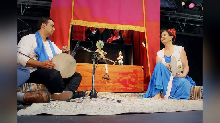 Musicians performing beside a puppet theatre, Tirgan 2013
