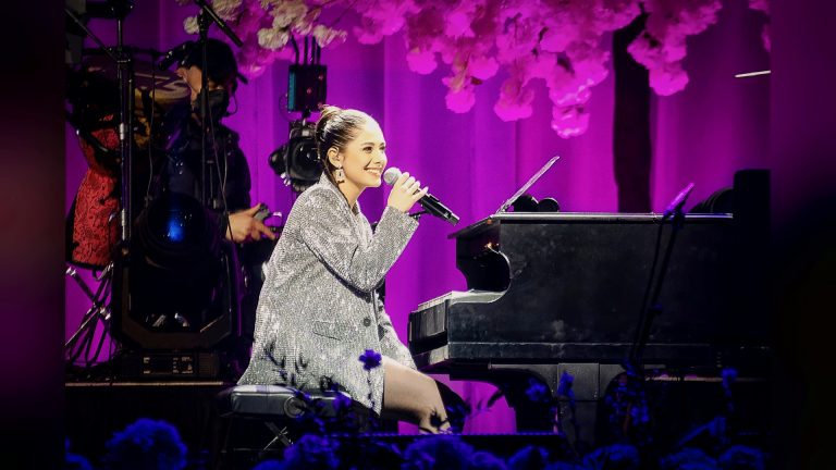 Singer performing at the piano under purple lights, For Iran, Tirgan Nowruz 2023